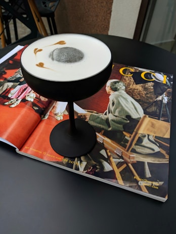 Close-up of a signature cocktail glass with the 'ö' symbol delicately etched on the rim.