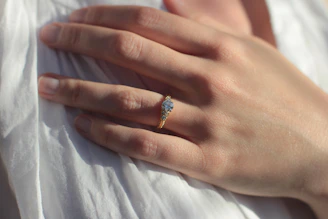 Close-up of a radiant natural blue Ceylon sapphire set in a gold ring, glowing under soft light.