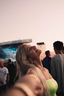 Candid shot of Bigg Britt laughing with fans after a high-energy performance, neon city backdrop illuminating the night.