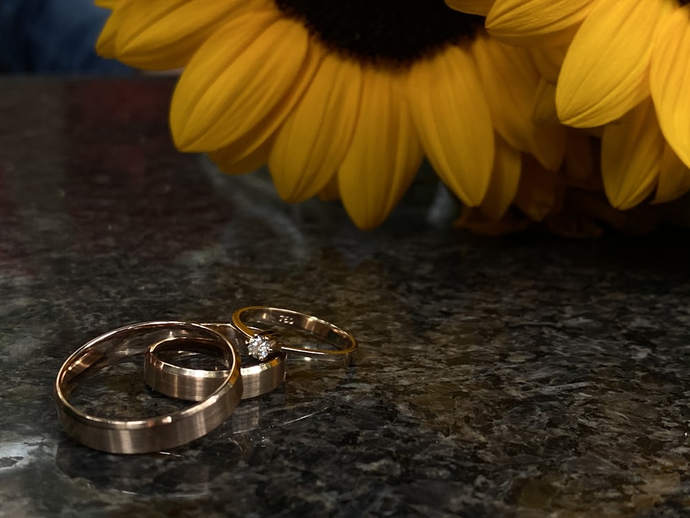 silver-colored ring and yellow Sunflowers