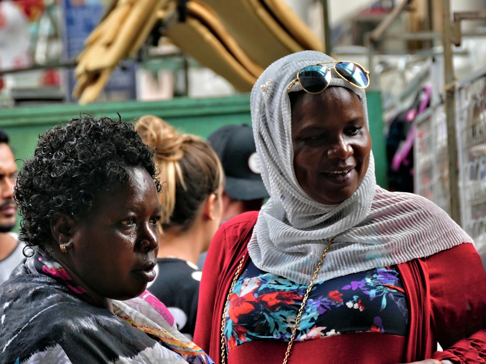 woman in white hijab beside person in black top