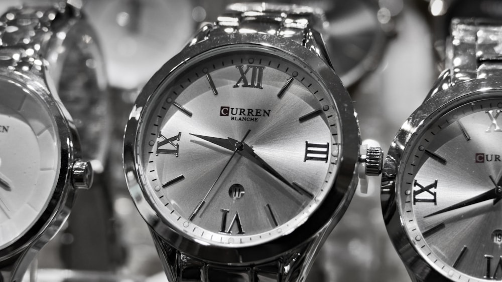 three round silver-colored Curren analog watches