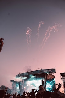 Crowd cheering at a vibrant outdoor concert in Dubai at sunset