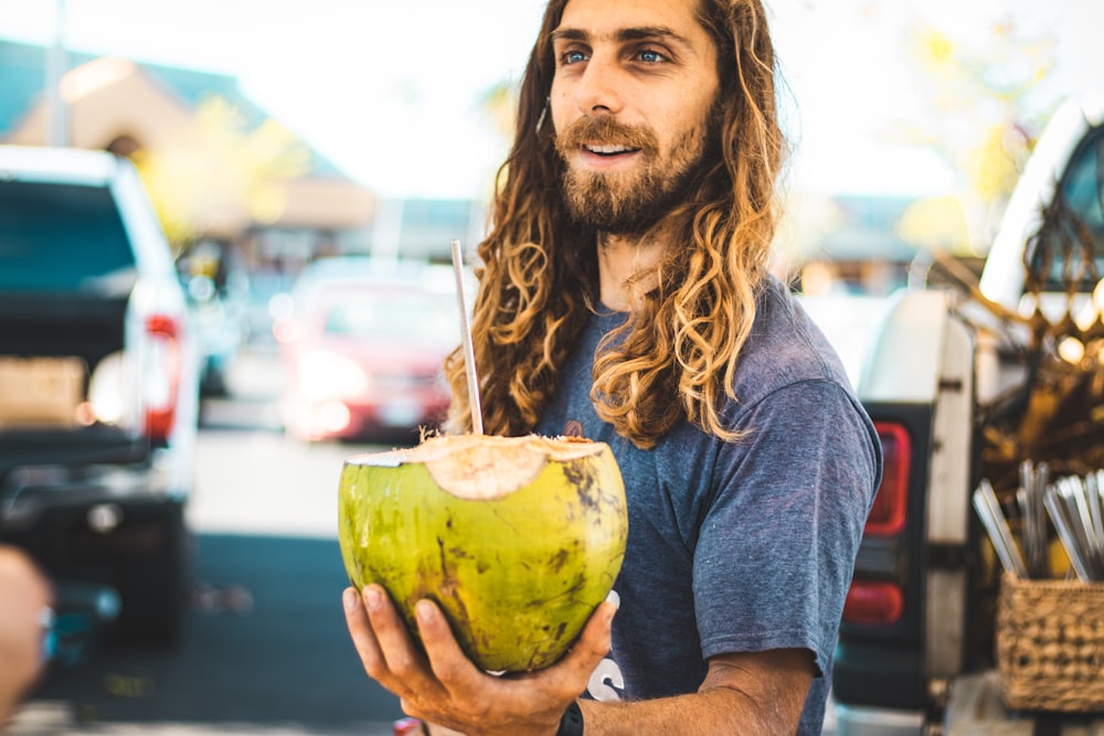 hombre sosteniendo la fruta del coco