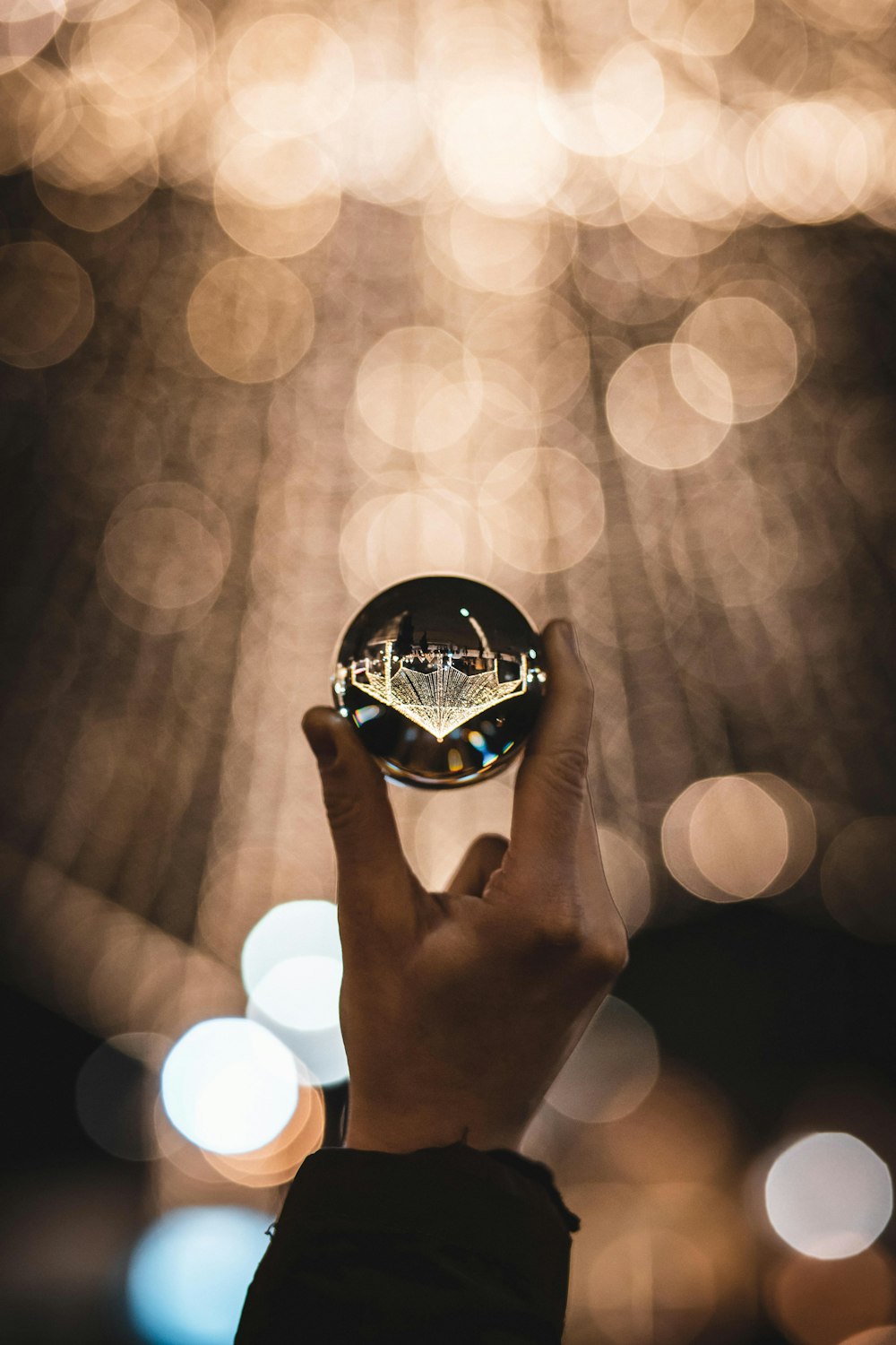 person holding glass sphere