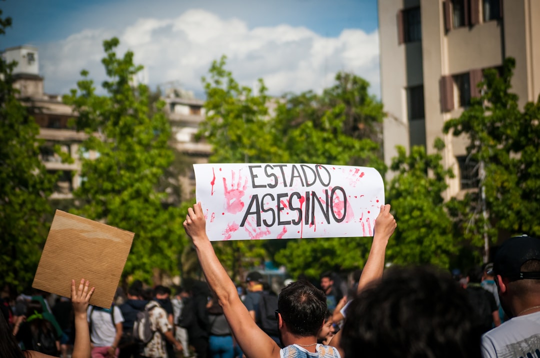 man holding signage displaying estado asesino text