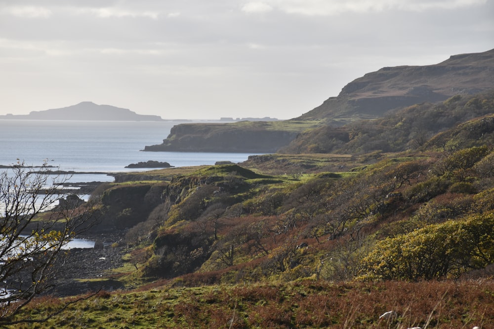 photography of mountain range beside seashore during daytime