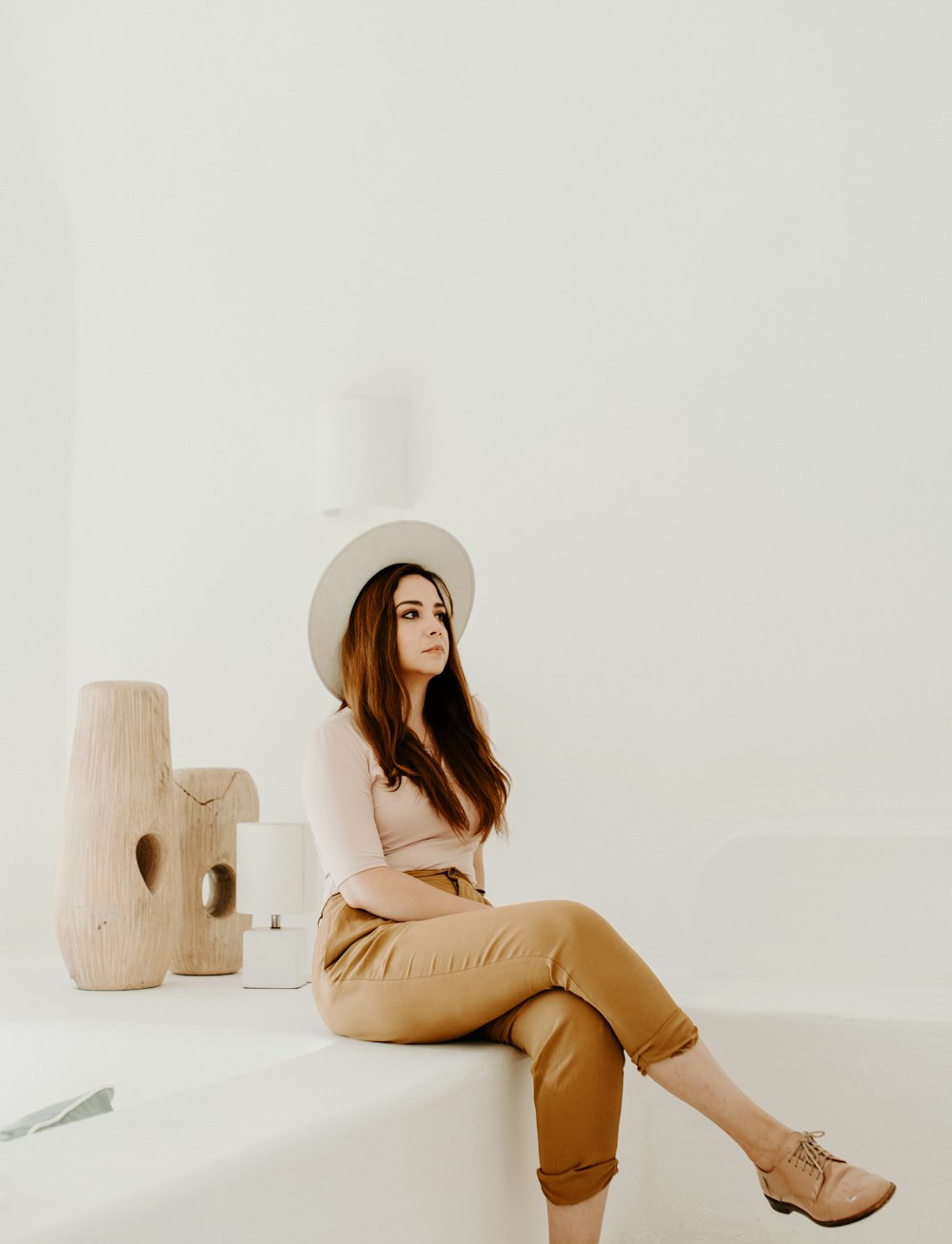 woman in beige crop-top sitting on white surface