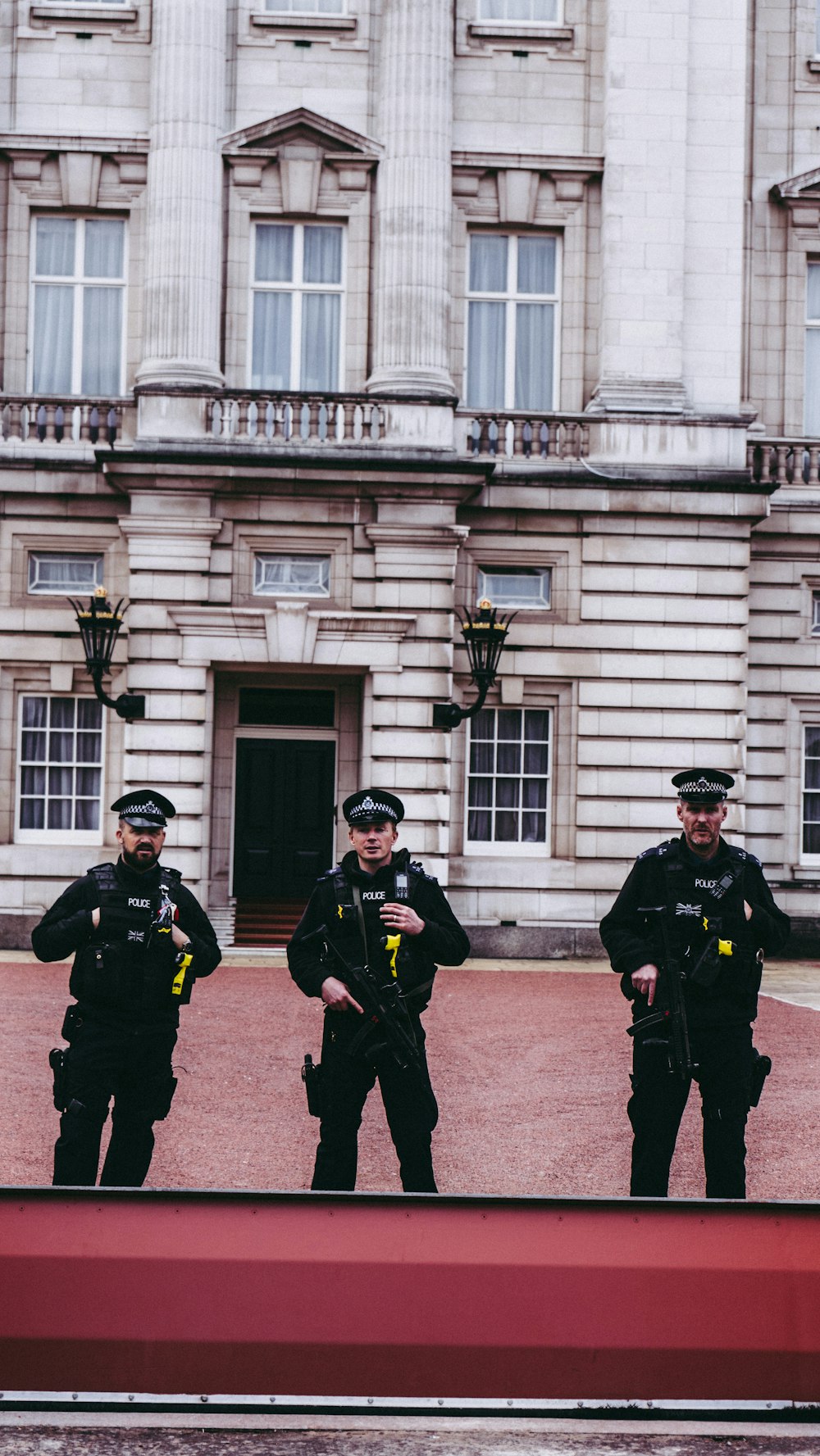 three police men standing in front of building