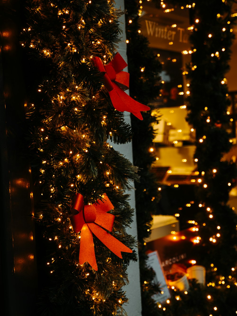 green Christmas wreath with string lights on wall