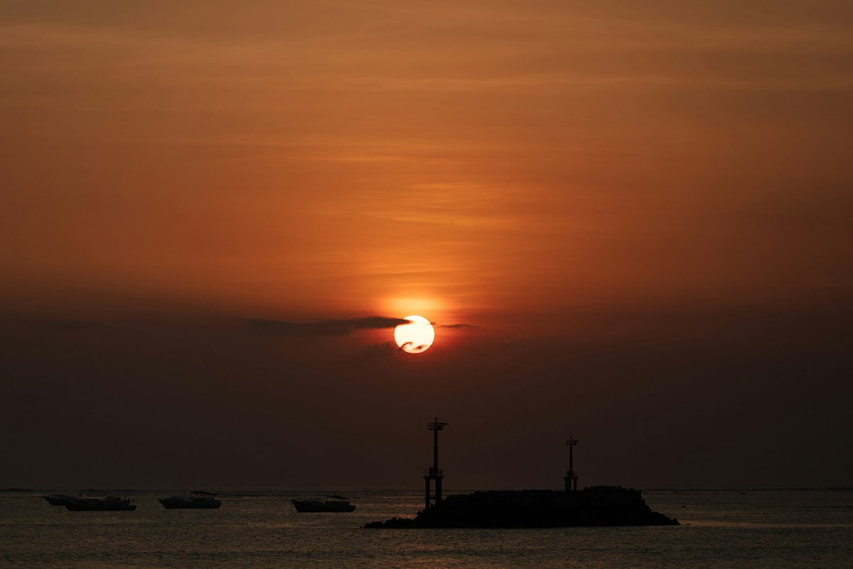 Boats on a calm Jimbaran Bay sea at sunset