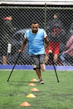 man wearing gray shirt and black cane playing soccer