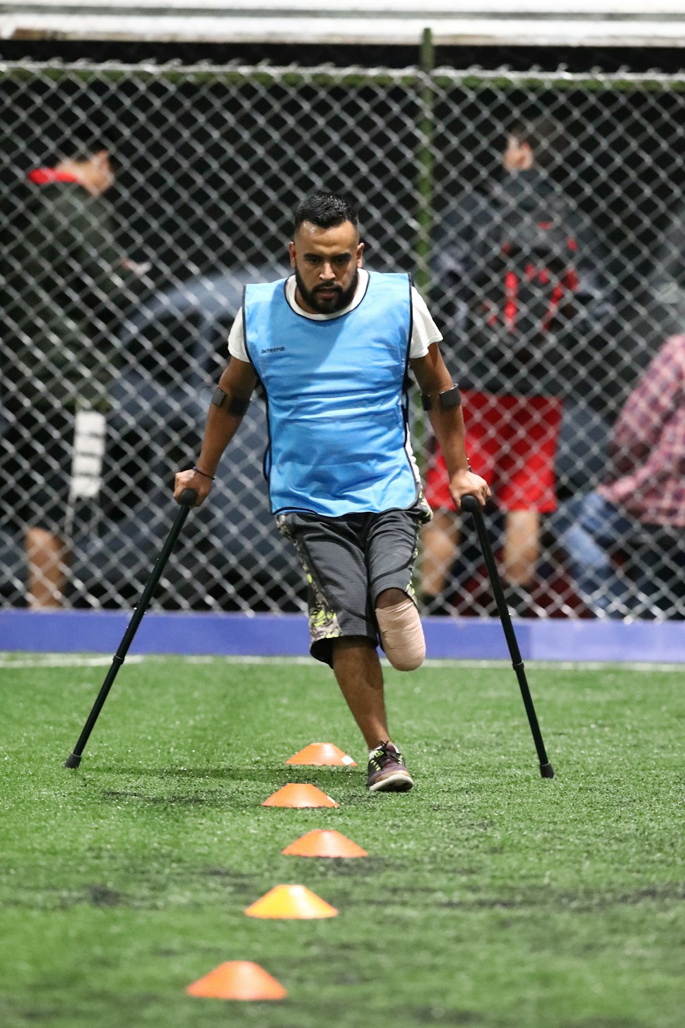 man wearing gray shirt and black cane playing soccer