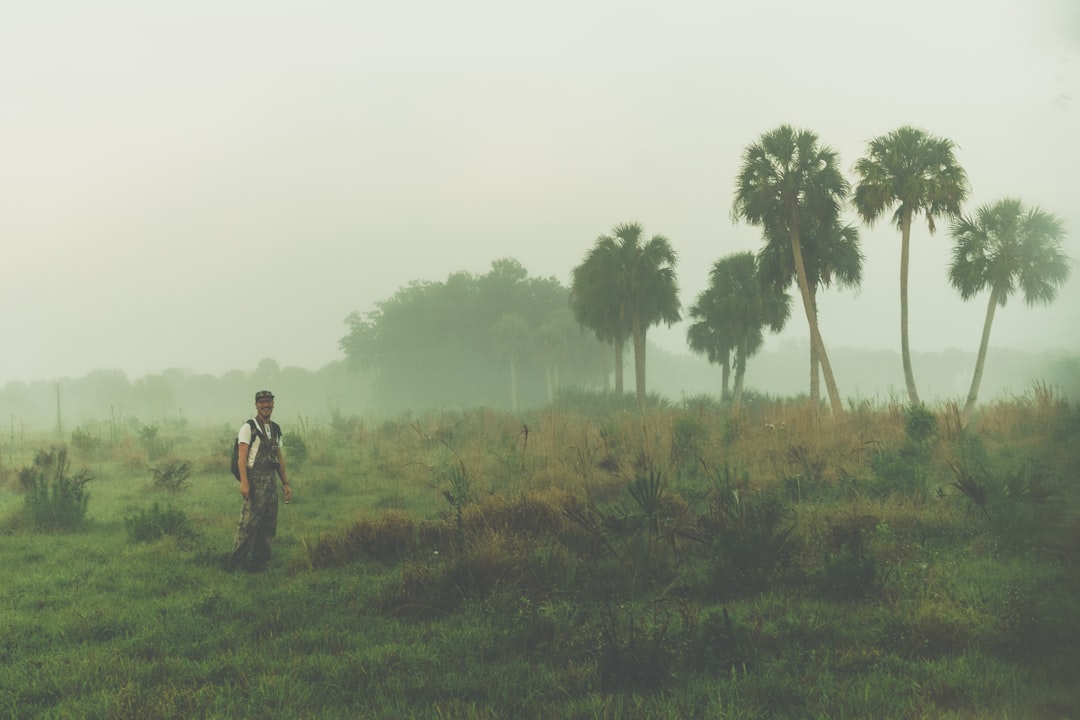 man standing near coconut trees during daytime