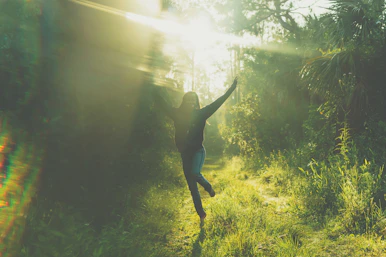 woman jumping near trees