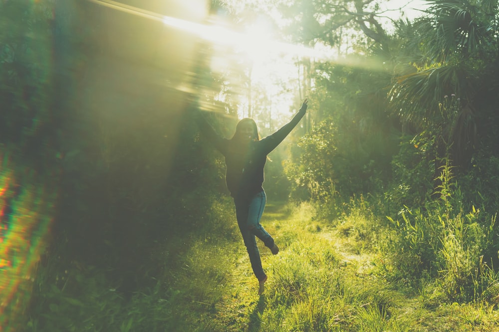 woman jumping near trees