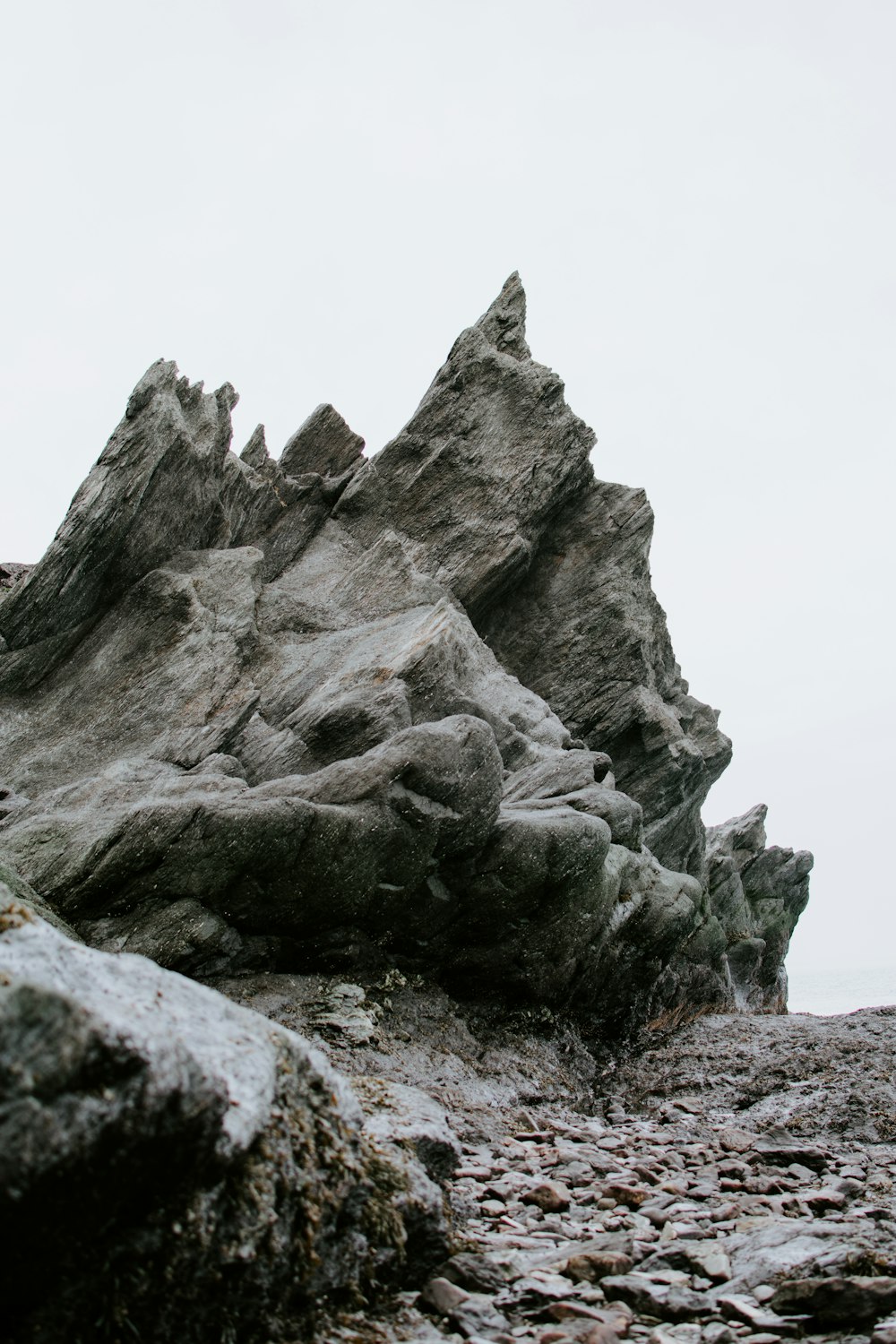 a large rock formation on a rocky beach