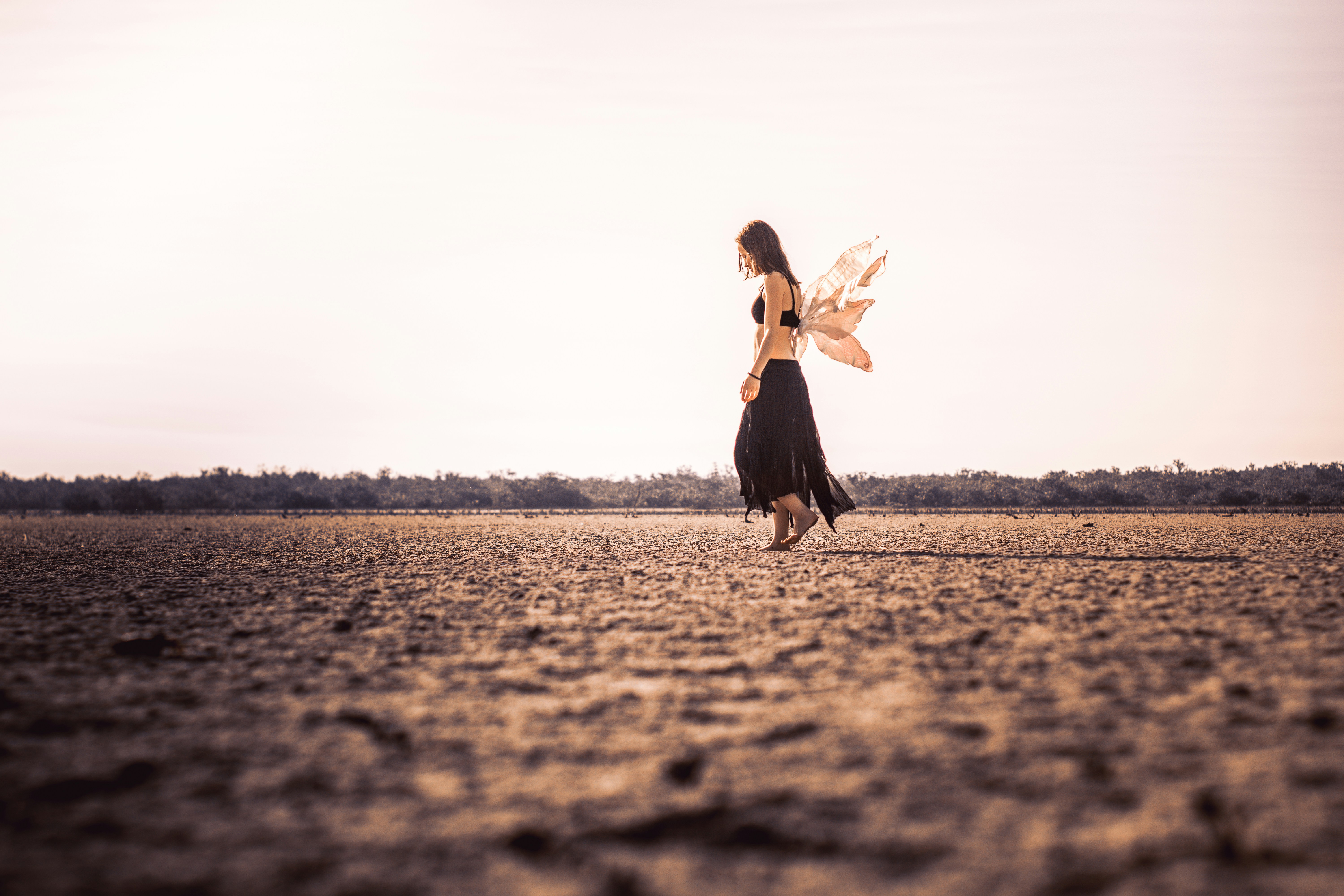 woman wearing black dress walking on open field, 