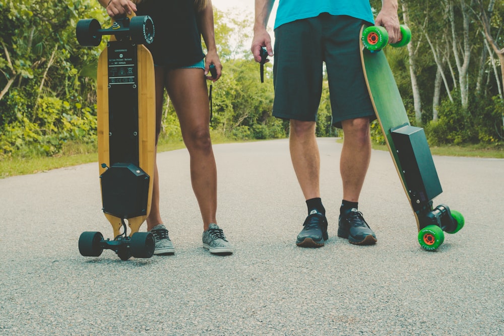 two person holding longboards