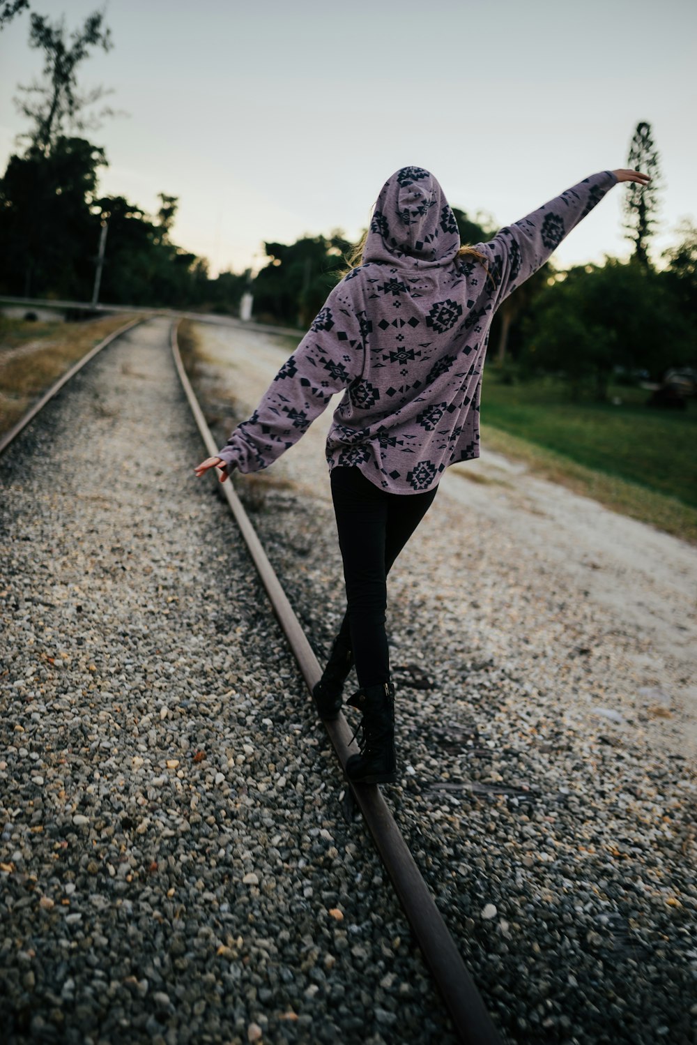 person wearing hoodie walking near road