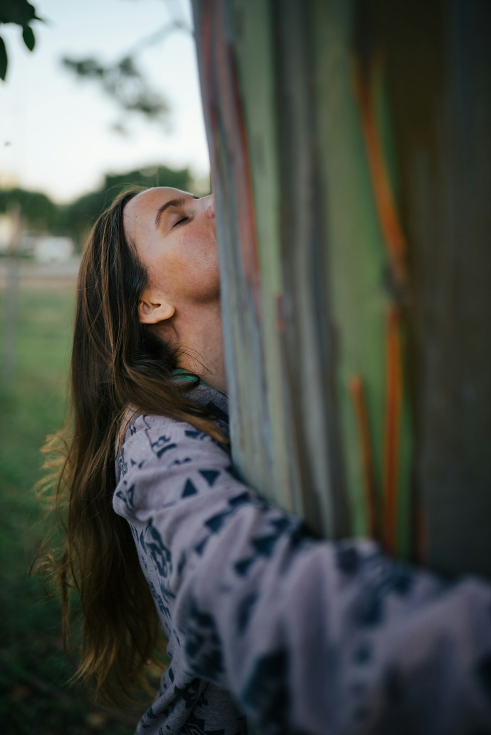 woman hugging tree trunk