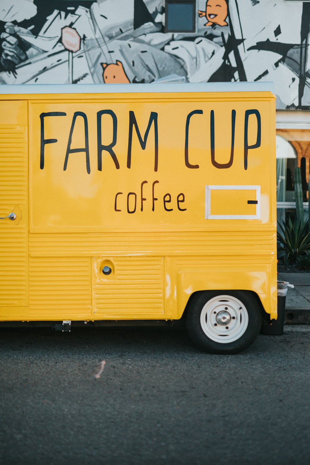 yellow Farm Cup Coffee truck parked beside sidewalk
