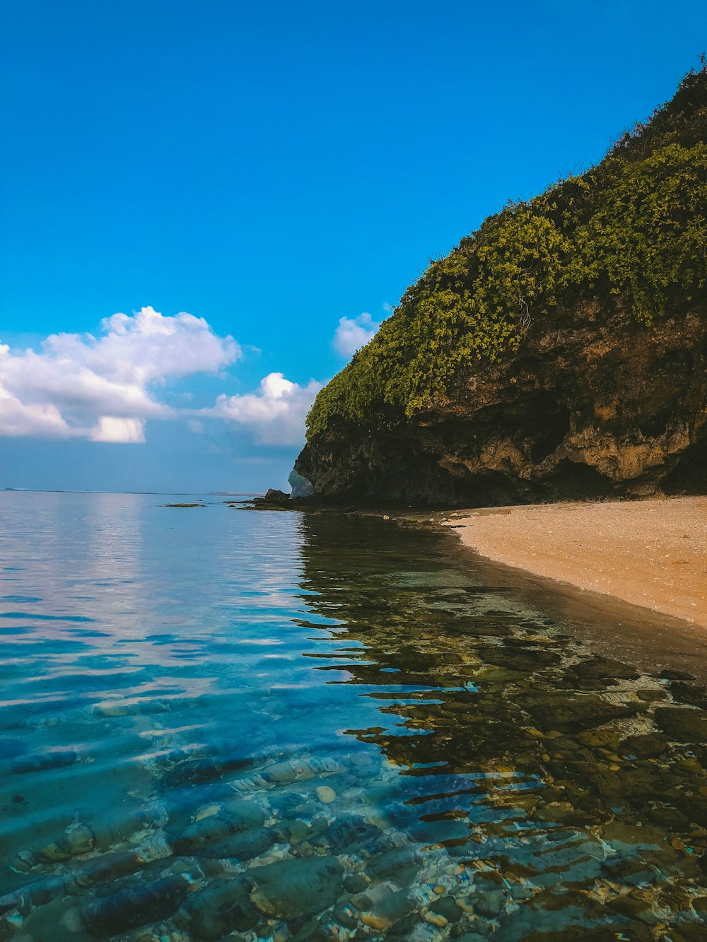 island and sea under blue sky