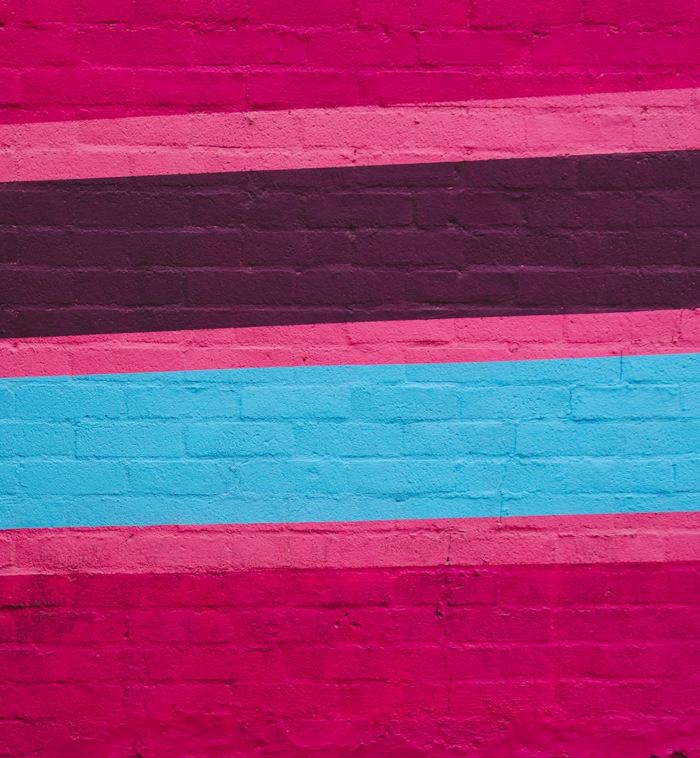 a brick wall with a blue and pink stripe painted on it