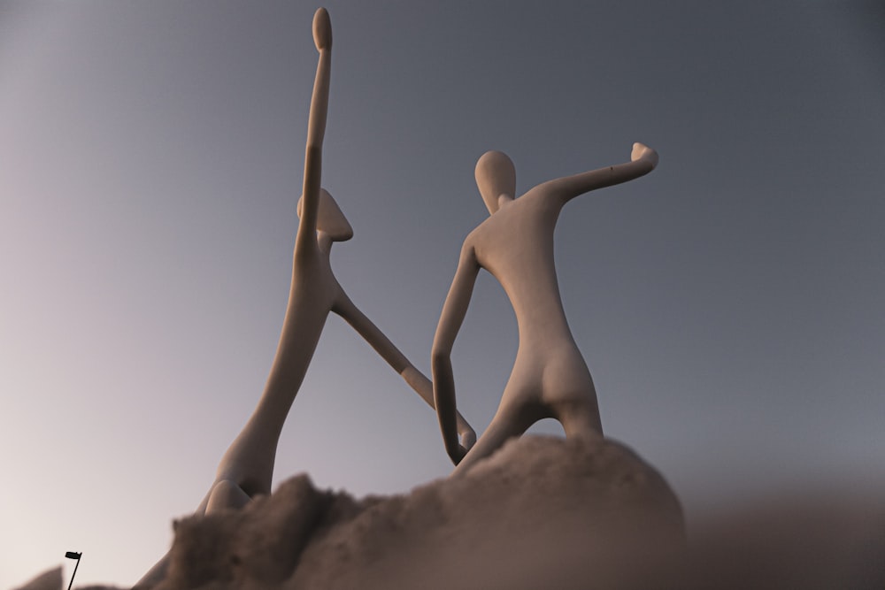 uma estátua de duas pessoas em pé no topo de uma colina