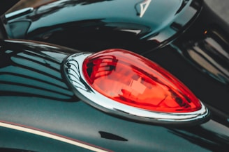 Close-up of a sleek black car with a glossy ceramic coating reflecting city lights.