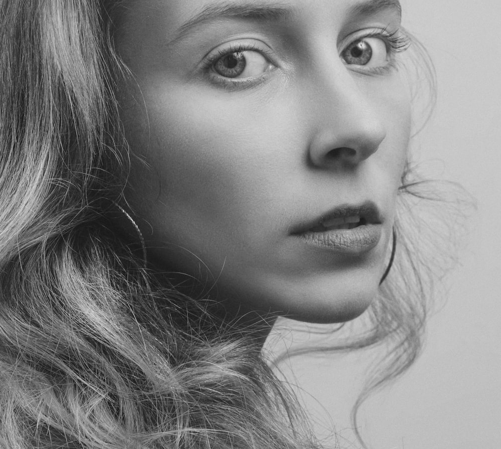 grayscale photo of woman wearing hoop earring