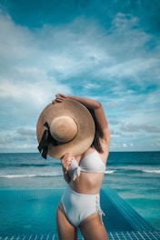 woman holding brown straw hat