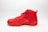 A red athletic high-top sneaker with intricate stitching and a textured sole is positioned on a plain white background. The shoe features a ribbed design along the sides and is equipped with matching red laces.