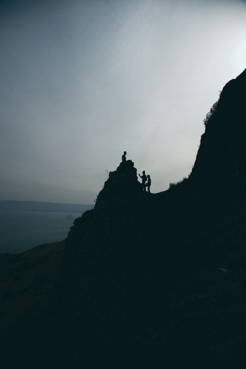 silhouette of people stand on mountain