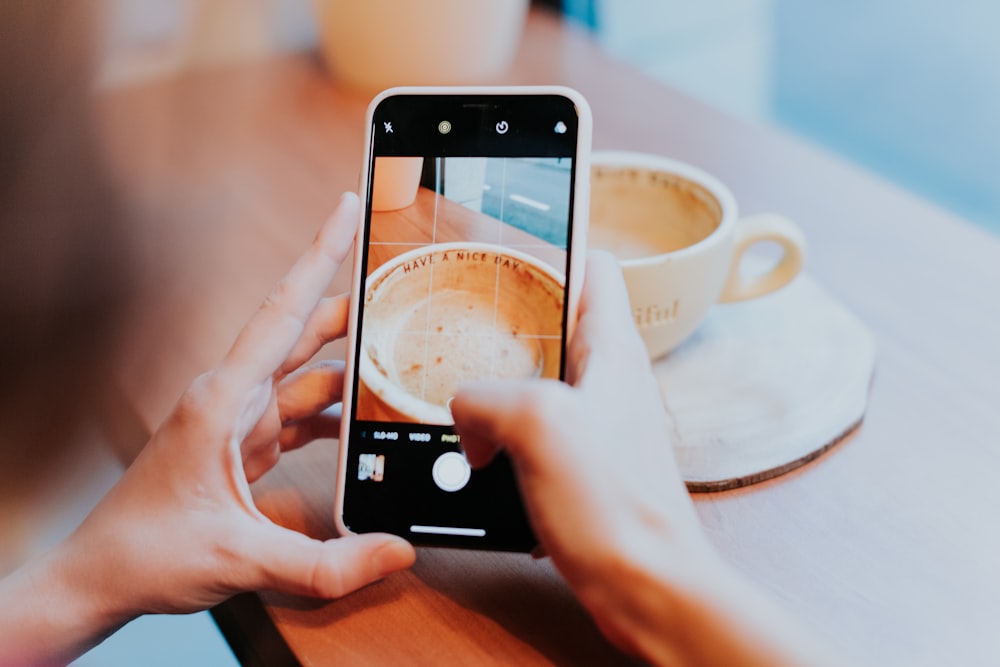 person capturing coffee cup