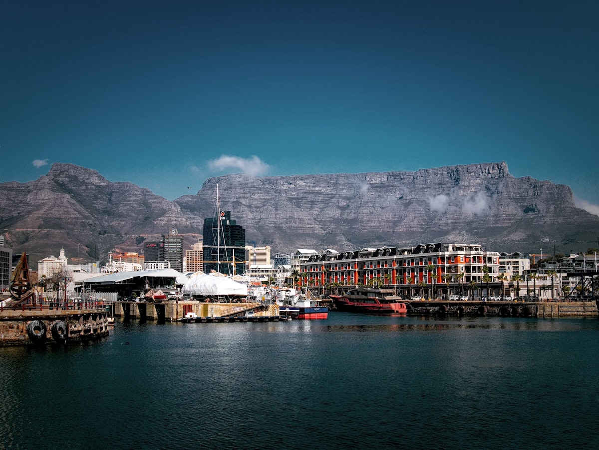 Cape Town December — V&A Waterfront buildings beside the harbour with Table Mountain in peak summer