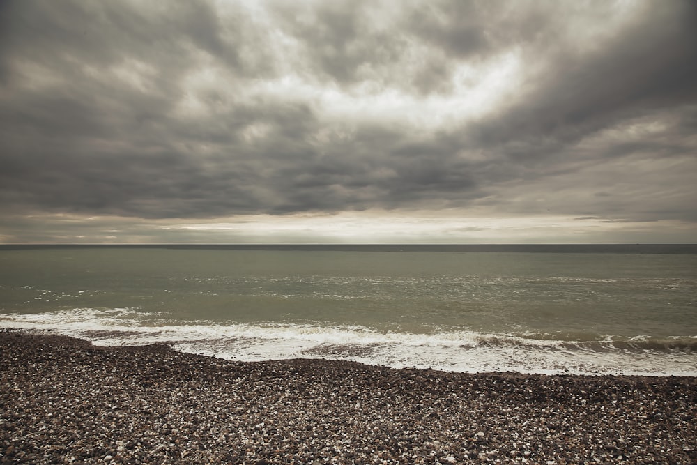 body of water under grey sky