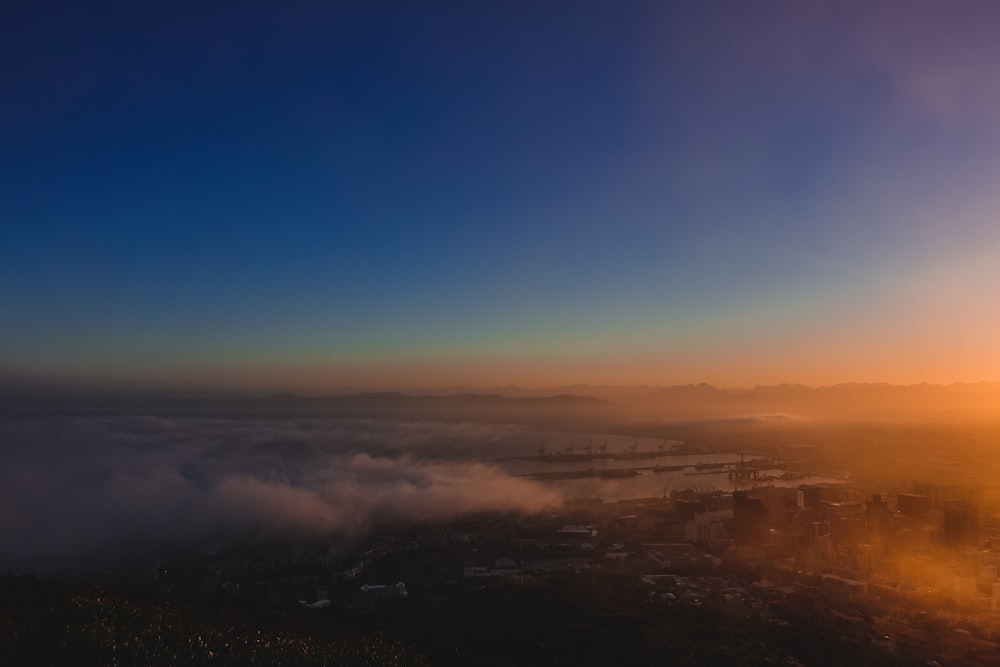 the sun is setting over the clouds in the sky