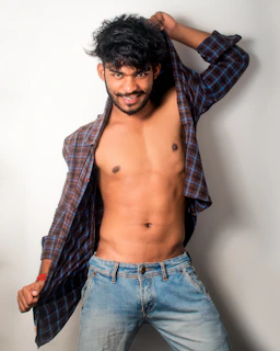 Jesse Roy relaxed backstage, lying on a couch with a playful smirk, embodying his badboy vibe.