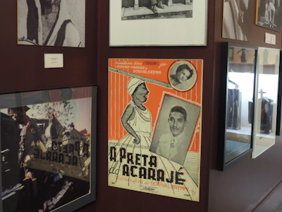 A colorful vintage poster framed and hanging on a rustic wall.
