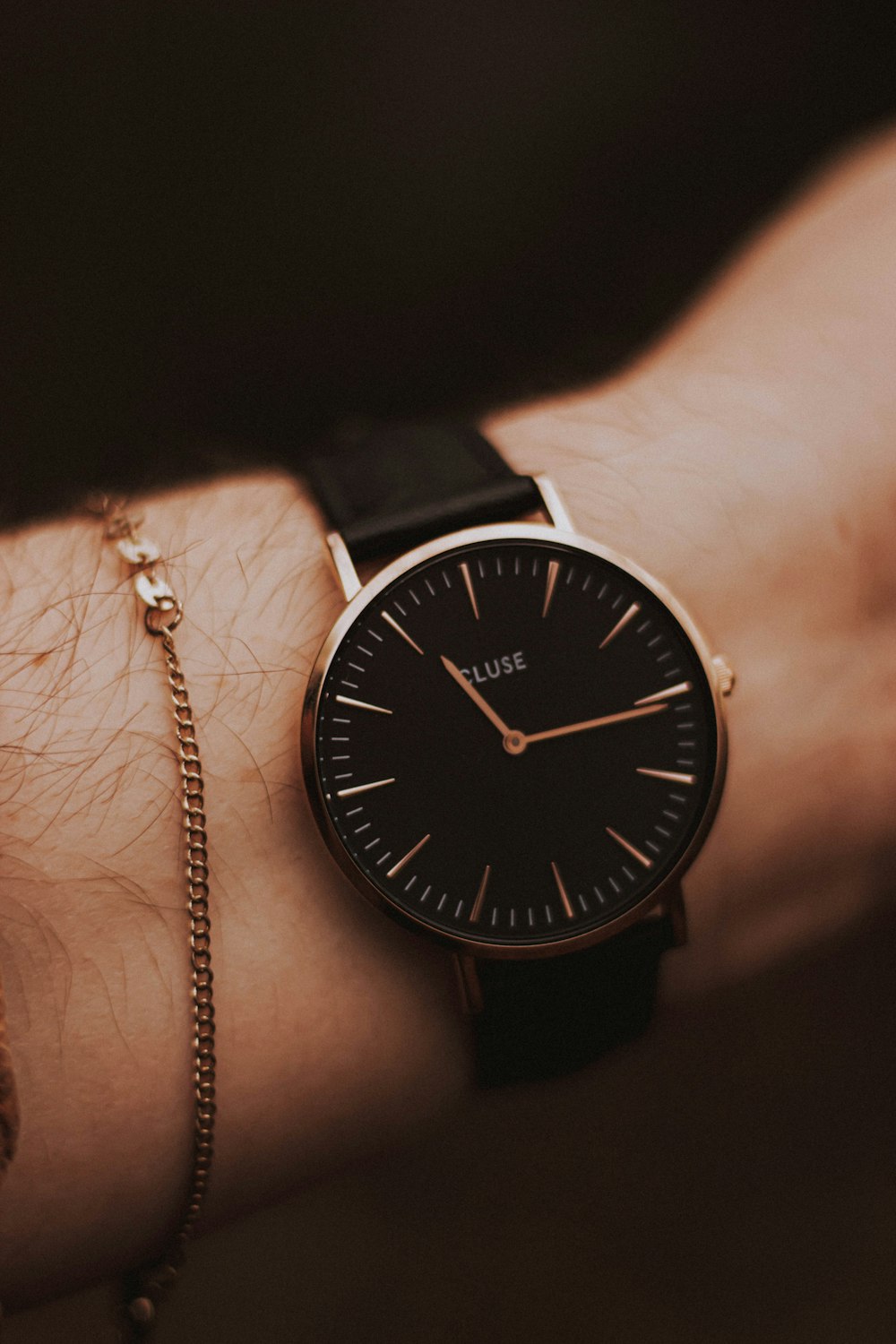 person wearing round copper-colored analog watch