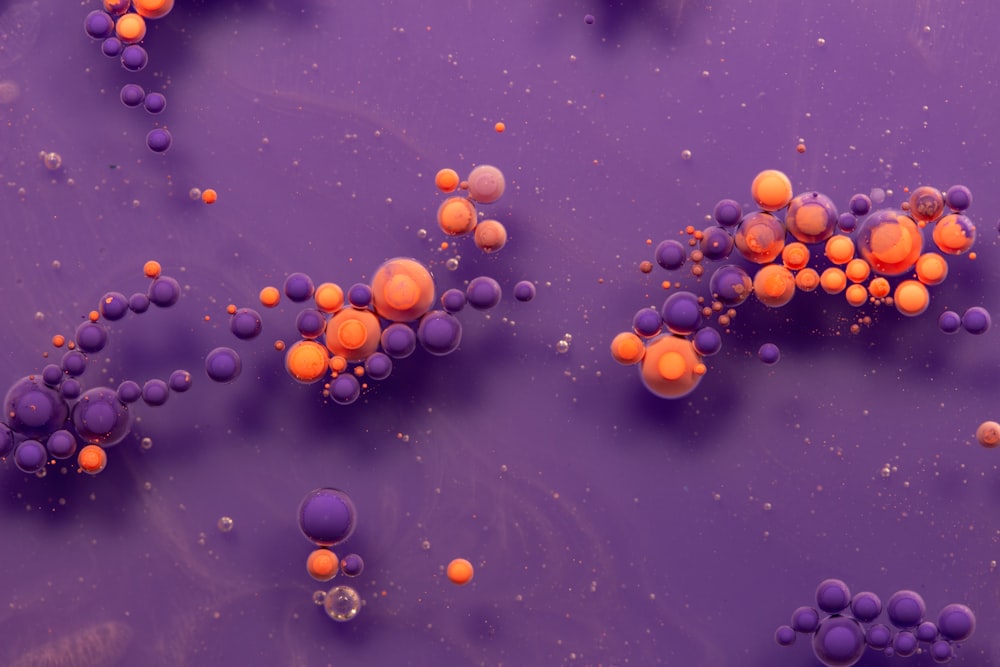Un gruppo di palline arancioni e viola su una superficie viola