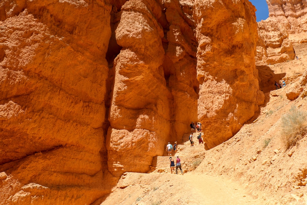people walking on brown rock formation during daytime