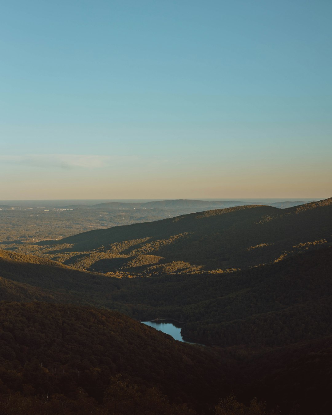 aerial photography of body of water viewing mountain under blue and white sky