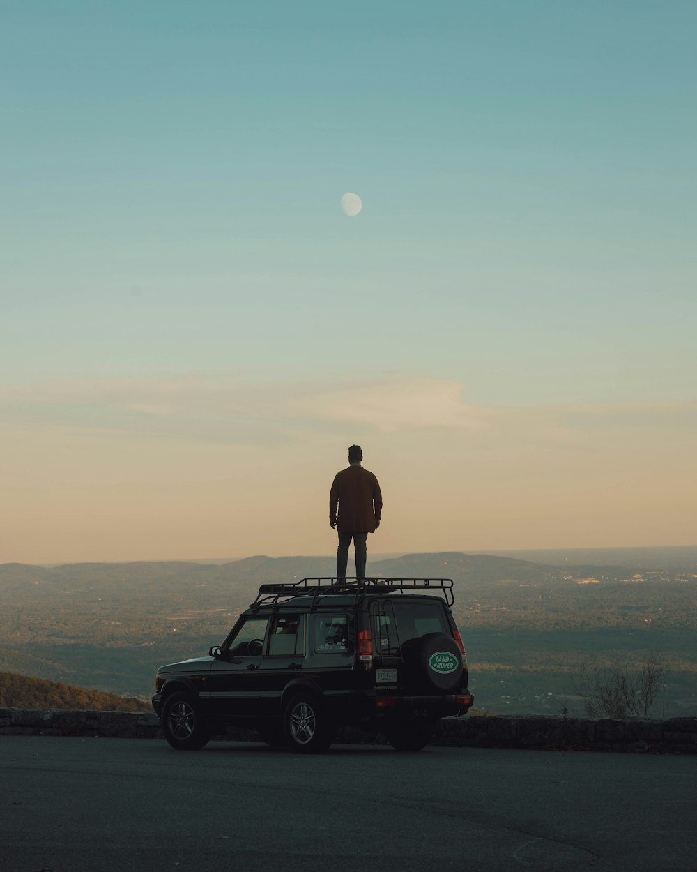 person standing on the roof of car