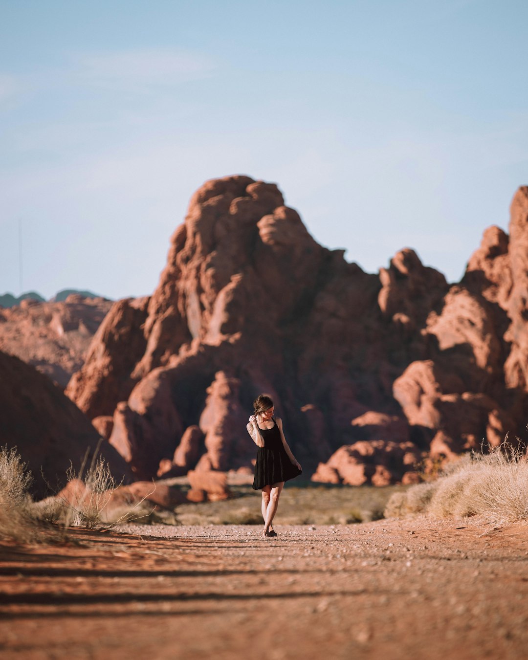 woman walking in front of rock cliff