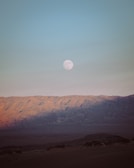 Wide shot of the desert landscape bathed in moonlight with silhouettes of drummers.