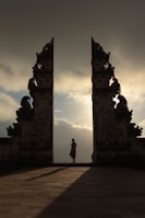 woman wearing beige dress in the middle of arch temple