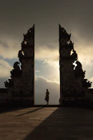 woman wearing beige dress in the middle of arch temple