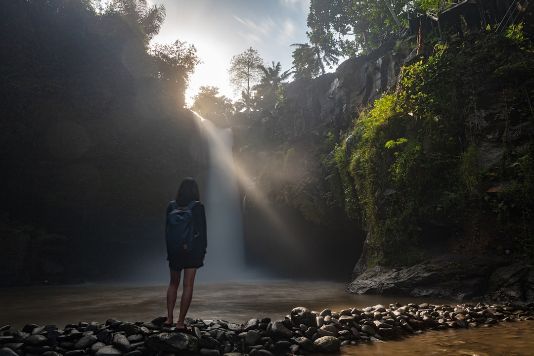 woman wearing black jacket looking at waterfalls screenshot